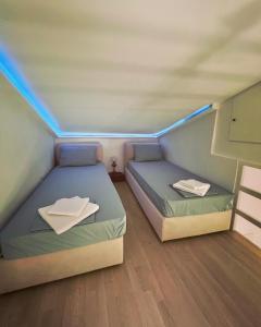 毕达哥利翁Stone Villa的小房间设有两张床,配有蓝色的灯光