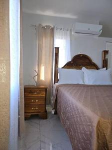 Old HarbourThe Cherryhill of Old Harbor的一间卧室配有一张床和一个带床头柜的木制梳妆台。