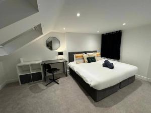 伦敦Modern 5 Bed near ExCel -Big Ben的一间卧室配有一张大床、一张桌子和一张四柱床。