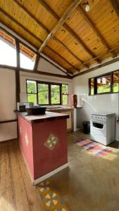 阿尤鲁奥卡Chalé Sabiá的带窗户的客房内设有带柜台的大厨房