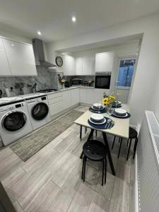 伦敦Modern 5 Bed near ExCel -Big Ben的厨房配有桌子和洗衣机