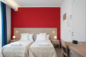 卡利亚里维拉斯维瓦酒店的红色墙壁的客房内的两张床