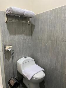 TjolomaduGenio Syariah Hotel Solo的一间小型浴室,配有白色卫生间和毛巾