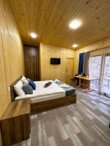 迪利然Haleb Hotel Complex的木制客房内的一间卧室配有一张大床