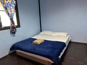 利邦岛Libong Garden Beach的一张带蓝色毯子的小床和一个窗口