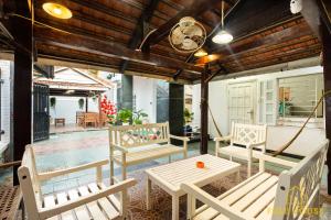 头顿Fullhouse Vũng Tàu Hotel TPVT的一个带白色椅子和桌子的门廊以及一个游泳池