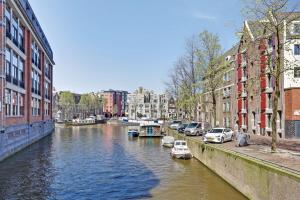 阿姆斯特丹City-centre, Canal-house, luxurious , stylish bedroom, ensuite bathroom, own entrance的一条有车停在河的一边