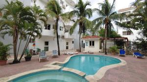 瓜亚卡内斯Residence Caribe的棕榈树酒店前的游泳池