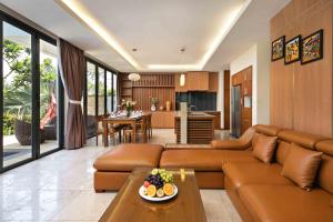 岘港Blue Ocean Villas Danang的一间带棕色沙发的客厅和一间厨房