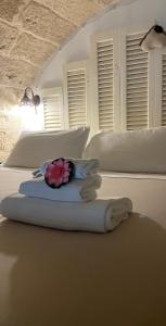 滨海波利尼亚诺卡萨菲奥雷住宿加早餐酒店的一间卧室配有两张床,上面有白色枕头和花朵