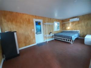 เคียงคลองโฮมสเตย์(สวนโควินท์)的卧室配有一张床铺,位于带木墙的房间内