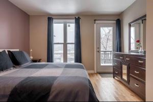 蒙特利尔5-STAR Prime Location - Bright Condo的一间卧室配有一张床、梳妆台和窗户。