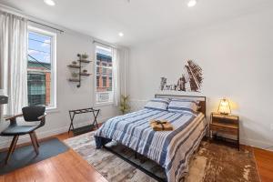 霍博肯Large Home Near NYC In Hoboken Sleeps 6的一间卧室配有一张床、一把椅子和窗户。