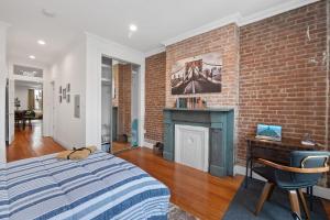 霍博肯Large Home Near NYC In Hoboken Sleeps 6的一间卧室设有砖墙、一张床和一个壁炉