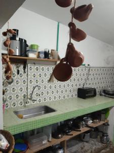 DibullaCasa de playa en Dibulla的厨房配有挂在墙上的锅碗瓢盆