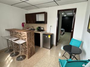 佩雷拉Acogedor apartaestudio ubicado en la zona rosa de Pereira的一个带柜台和椅子的厨房