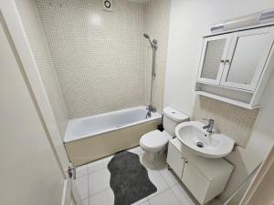 伦敦2bdr Islington close to station的浴室配有盥洗盆、卫生间和浴缸。