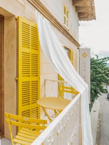 桑特略伦斯斯德斯卡尔达萨尔Hotel Boutique Can Pocovi的阳台配有桌椅和黄色百叶窗