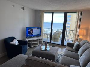 新士麦那海滩Coastal Condo on the beach at Ocean Trillium #501的带沙发和电视的客厅以及阳台。