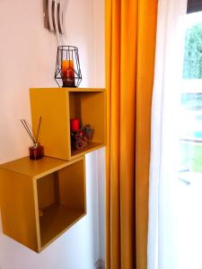 Los TomillaresVILLA TOMILLARES的黄色的橱柜,旁边是带橙色窗帘的窗户