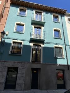 哈卡Ático abuhardillado imak Jaca的蓝色的建筑,设有窗户和门