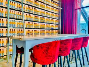 吉隆坡Scarletz Suites KLCC by M Suites的一间酒吧,配有红色椅子和瓶装葡萄酒