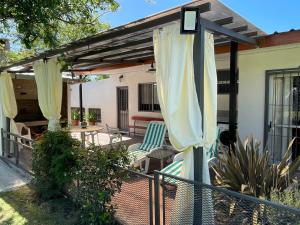 科洛尼亚-德尔萨克拉门托Magnolio的庭院设有遮阳篷、椅子和桌子