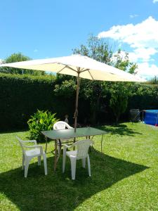 GualeguaychúComo en casa的院子里伞下的桌子和椅子