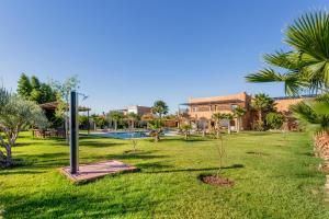 马拉喀什leila farmhouse的一座带游泳池和棕榈树的庭院和一座建筑