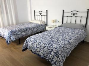 哈恩Centrico alojamiento的一间卧室配有两张带蓝白色棉被的床