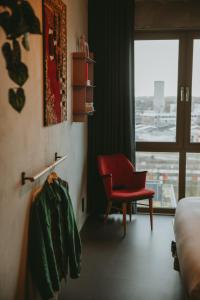 阿姆斯特丹Hotel Jansen Amsterdam Bajeskwartier的酒店客房设有红色椅子和窗户。
