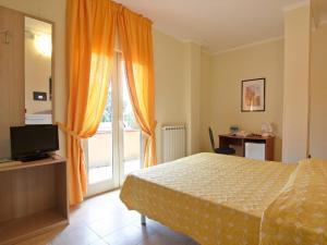 罗迪-加尔加尼科Residence Parco del Sole的一间卧室配有一张床、一台电视和一个窗口