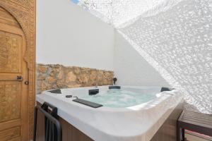 多列毛利诺斯Seaside Tranquility and Urban Luxury - Stylish Duplex in Torremolinos w jacuzzi的带浴缸的客房。