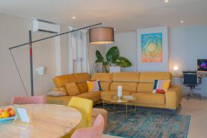 多列毛利诺斯Seaside Tranquility and Urban Luxury - Stylish Duplex in Torremolinos w jacuzzi的客厅配有沙发和桌子