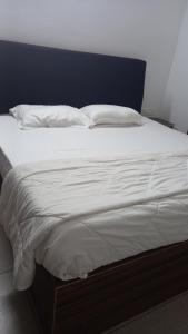 德里久尔Niks home stay - A的一张配有白色床单和枕头的大床