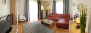 奥伯劳Apartment Morgensonne的客厅配有红色沙发和电视