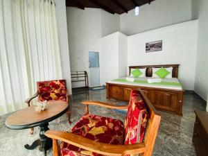 康提Kandyan View Homestay -For Foreign的卧室配有一张床和一张桌子及椅子