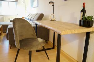 耶拿3-Raum City-Appartement Jena的桌椅和一瓶葡萄酒