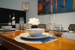 耶拿3-Raum City-Appartement Jena的木桌,带盘子、碗和酒杯