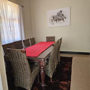 利文斯顿Mukamba Private Holiday Home的用餐室配有桌椅和斑马图片