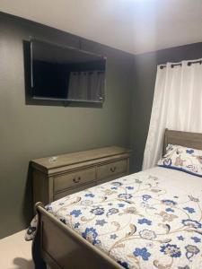 金斯敦New Kingston Retreat的一间卧室配有一张床、梳妆台和镜子