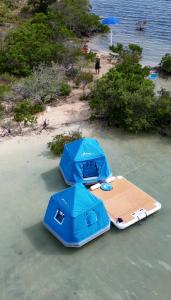 基韦斯特Bonnethead Key Floating Campground and Private Island的两张桌子和遮阳伞,在靠近水面的海滩上