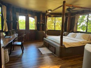 科隆Sangat Island Dive Resort的一间卧室配有一张天蓬床和一张书桌