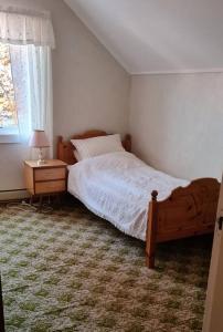 SundSkipperhuset的一间卧室配有一张床、一张桌子和一个窗户。