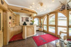 塞尔瓦迪加尔代纳山谷Garni la Bercia的一间设有红色地毯和大窗户的家庭办公室
