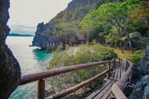 科隆Sangat Island Dive Resort的悬崖上的长凳,俯瞰着大海