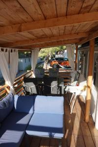 耶泽拉DM mobile home的甲板上配有沙发和椅子的门廊