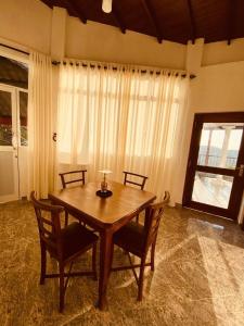 康提Kandyan View Homestay -For Foreign的一间带木桌和椅子的用餐室
