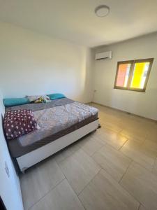 贝贝里比Villa Amarelo的卧室配有1张床,铺有瓷砖地板。