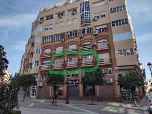 韦尔瓦"El Balcón de Huelva" lujo en pleno centro的上面有绿色标志的高楼